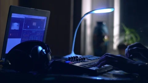 The guy plays the keyboard at night in an atmospheric home environment. Stock Footage 129853534