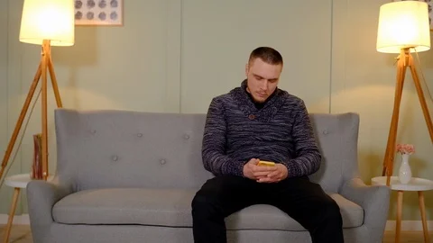 A guy plays mobile games, and his girlfriend takes away his smartphone Video stock 126933472