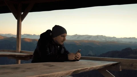 The guy plays on the phone in the Mountain Ranges Stock Footage 98451060