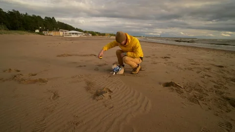 The guy plays with a small Spitz dog at sunset on the beach near the sea Stock Footage 172055639