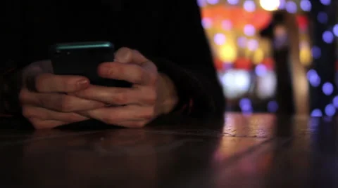 A guy plays with a smartphone in cafe bokeh background Video stock 47763201