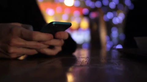 A guy plays with a smartphone in cafe bokeh background Video stock 47770809