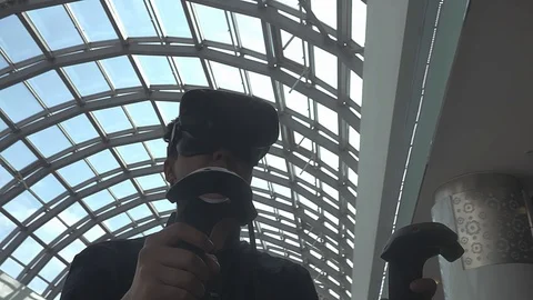 The guy plays in the virtual reality at a meeting events of computer game fans. Stockbeeldmateriaal 88533174