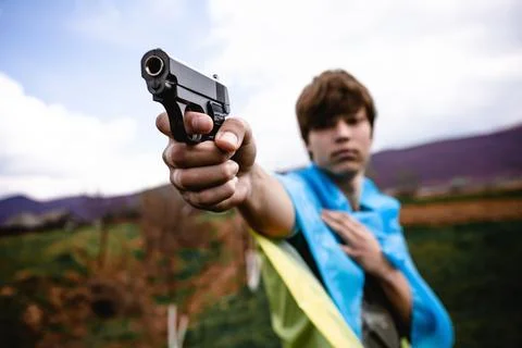 The guy pointed the gun. No war in Ukraine. Background sky and mountains. Stock Photos