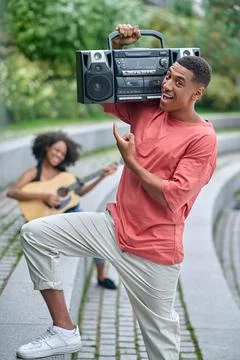 Guy pointing at record-player holding on shoulder Stock Photos