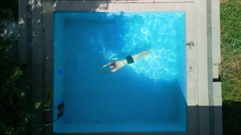Guy in the pool on a bright sunny day, sporty guy in shorts Stock Footage 250874800
