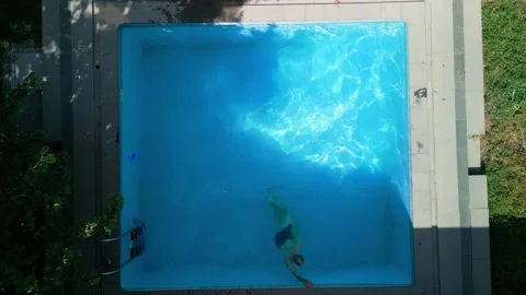 Guy in the pool on a bright sunny day, sporty guy in shorts Stock Footage 250908920