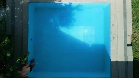 Guy in the pool on a bright sunny day, sporty guy in shorts Stock Footage 251007452