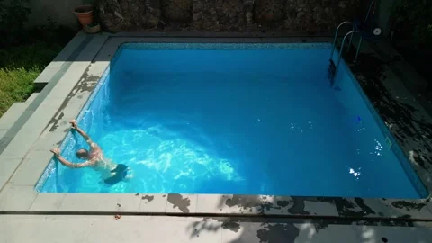 Guy in the pool on a bright sunny day, sporty guy in shorts Stock Footage 251008675