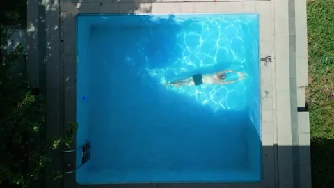 Guy in the pool on a bright sunny day, sporty guy in shorts Video stock 251009737