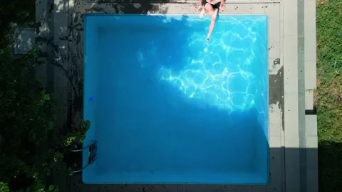 Guy in the pool on a bright sunny day, sporty guy in shorts Stock Footage 251009922