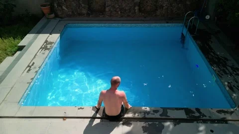 Guy in the pool on a bright sunny day, sporty guy in shorts Stock Footage 251029386