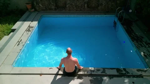 Guy in the pool on a bright sunny day, sporty guy in shorts Stock Footage 251068590