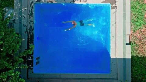 Guy in the pool on a bright sunny day, sporty guy in shorts Stock Footage 251232420