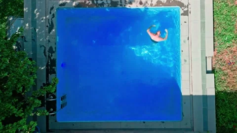 Guy in the pool on a bright sunny day, sporty guy in shorts Stock Footage 251235022