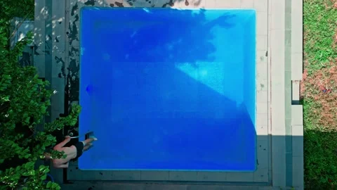 Guy in the pool on a bright sunny day, sporty guy in shorts Stock Footage 251237307