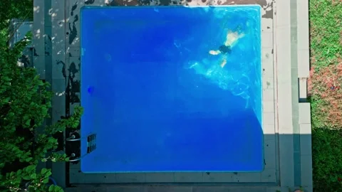 Guy in the pool on a bright sunny day, sporty guy in shorts Stock Footage 251239322