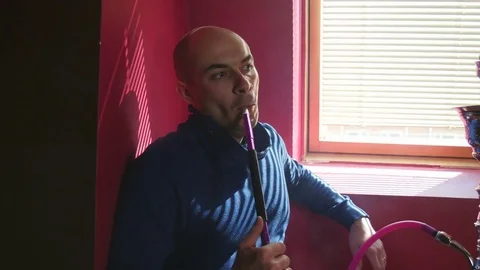 The Guy Portrait Smoking Hookah in a Bar Breath out Smoke Stock Footage 75258322