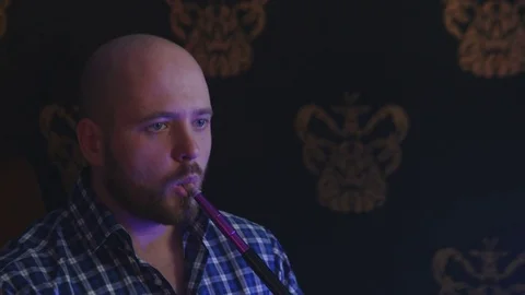 The Guy Portrait Smoking Hookah in a Bar Breath out Smoke Stock Footage 75258670