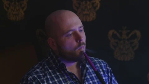 The Guy Portrait Smoking Hookah in a Bar Breath out Smoke Stock Footage 75258937