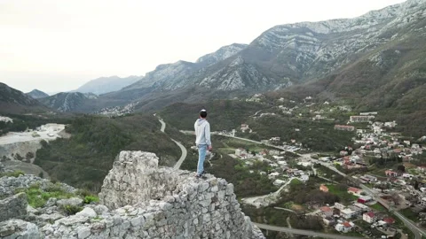 The guy poses against the backdrop of the mountains of Montenegro Stock Footage 195105382