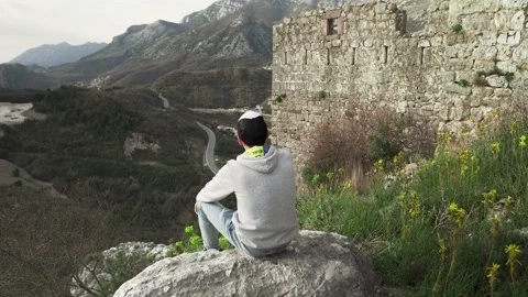 The guy poses against the backdrop of the mountains of Montenegro Stock Footage 195105452