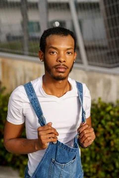 Guy posing in a white shirt and overalls Stock Photos
