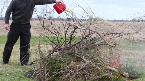 Guy pours gasoline onto fire Stock Footage 49733197