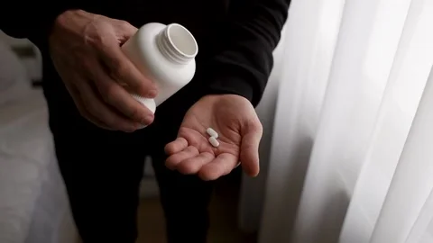 The guy pours two pills on his hand. Stock Footage 231814238