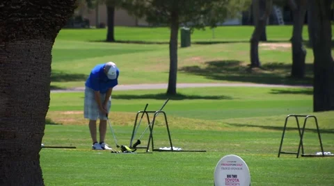 Guy practices his stroke on golf course Stock Footage 62846247