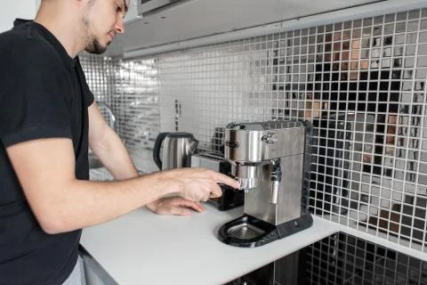 Guy prepare delicious aromatic coffee in a coffee machine. A simple way to ma Stock Photos