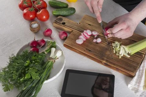 The guy prepares a vegetable salad Fotos de archivo