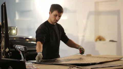 The guy is preparing material for soundproofing Stock Footage 56024364