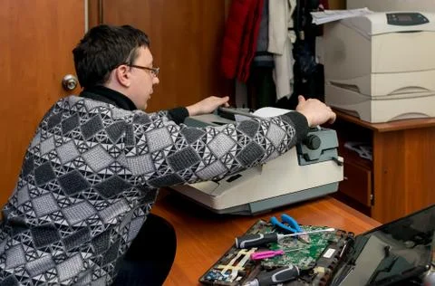 A guy prints documents on mechanical typewriter Stock Photos