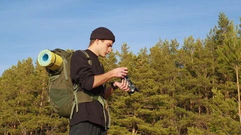Guy with professional camera takes pictures in woods Stock-Footage 255801073