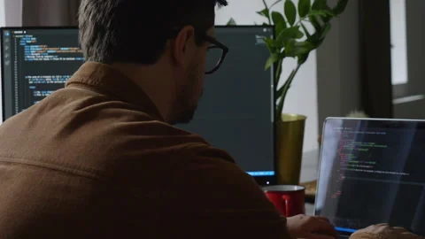 Guy programmer writes code on a computer at home Stock Footage 150456121