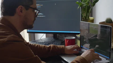 Guy programmer writes code on a computer at home 스톡 동영상 150456522