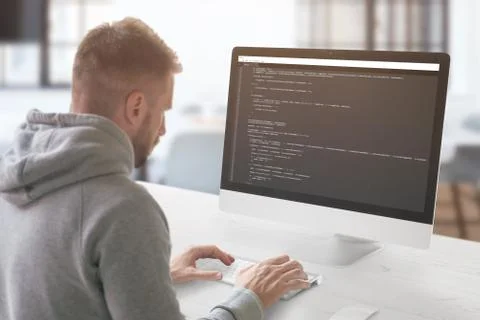 The guy programming on a computer in the office. Stock Photos