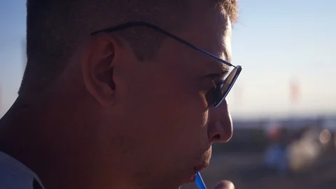 The guy in the protective sleeves drinks a drink from a glass through a straw Stock Footage 102569530