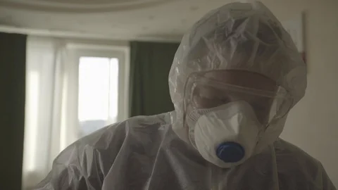 A guy in a protective suit is Ironing things Stock Footage 127354521