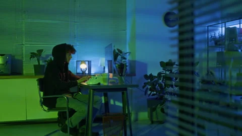 Guy Pulling Hoodie over Head Gaining Unauthorized Access to Computer System Stock Footage 299257156