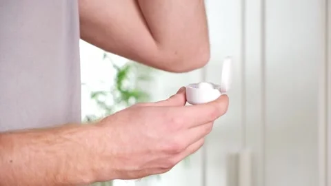 Guy pulls out case and inserts wireless headphones into ears. Young man showing Stock Footage 239447439