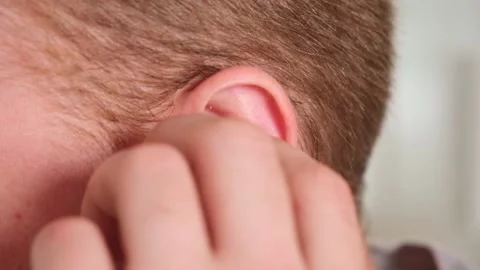 Guy pulls out case and inserts wireless headphones into ears. Young man showing Stock Footage 239447796
