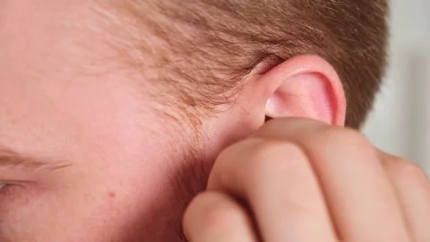 Guy pulls out case and inserts wireless headphones into ears. Young man showing Stock Footage 239816800
