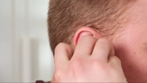 Guy pulls out case and inserts wireless headphones into ears. Young man showing Stock Footage 239816825