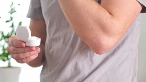 Guy pulls out case and inserts wireless headphones into ears. Young man showing Stock Footage 241424186