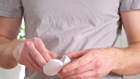 Guy pulls out case and inserts wireless headphones into ears. Young man showing Stock Footage 241927621