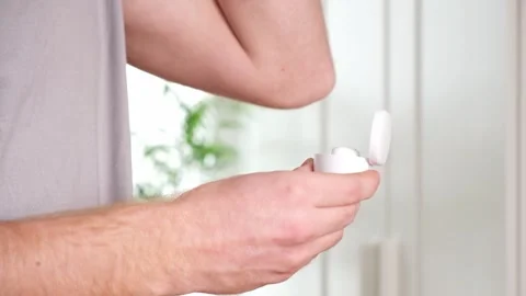 Guy pulls out case and inserts wireless headphones into ears. Young man showing Stock Footage 242298768