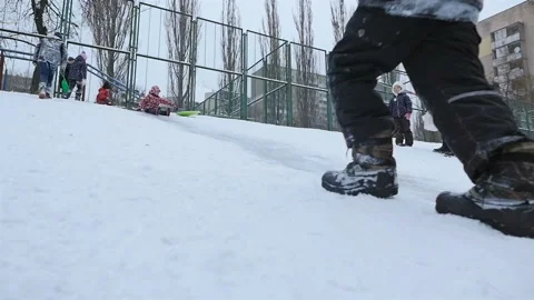 A guy pulls a sleigh on a snowy hill. Slow motion 01.10.2020 Ukraine, Kiev Stock Footage 126643112