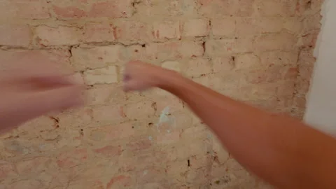 A guy punches a brick wall with his bare fists. Karate training. Stock Footage 317973523